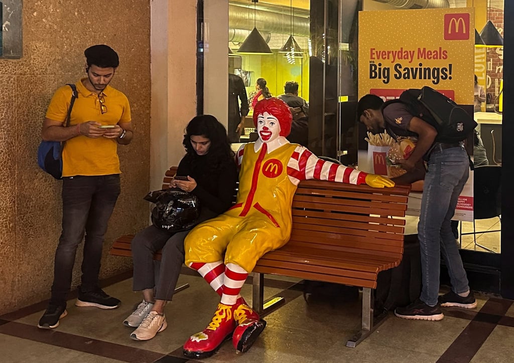 A person sits outside a McDonald’s restaurant in Mumbai, India. Photo: Reuters