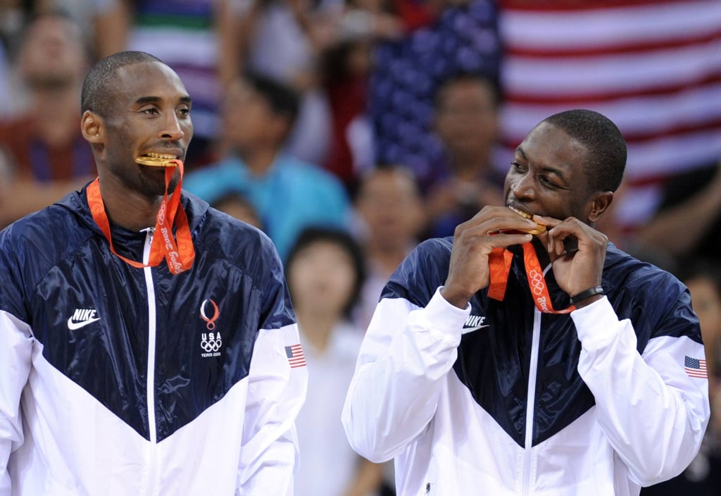 USA’s Kobe Bryant (left) and Dwyane Wade bite their medals on the podium after winning gold at the 2008 Olympics in Beijing. Photo: AFP