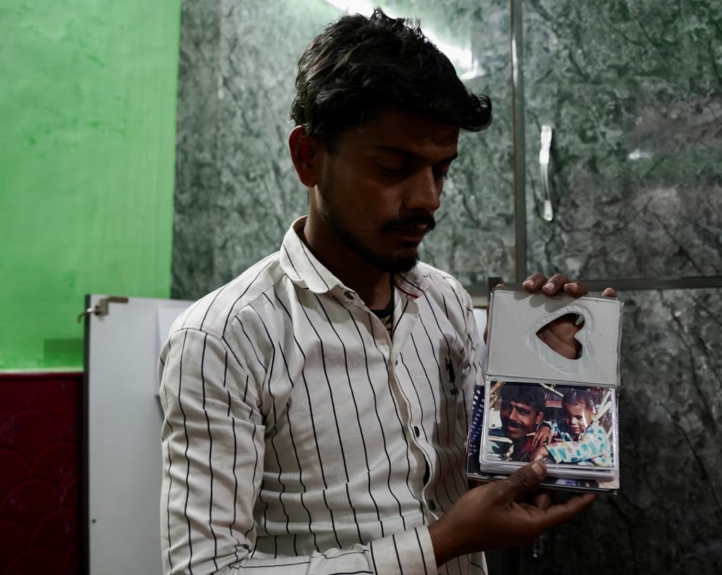 Mohammad Aman shows a picture of his father Mohammad Zahid and brother Anas. Photo: Bhat Burhan