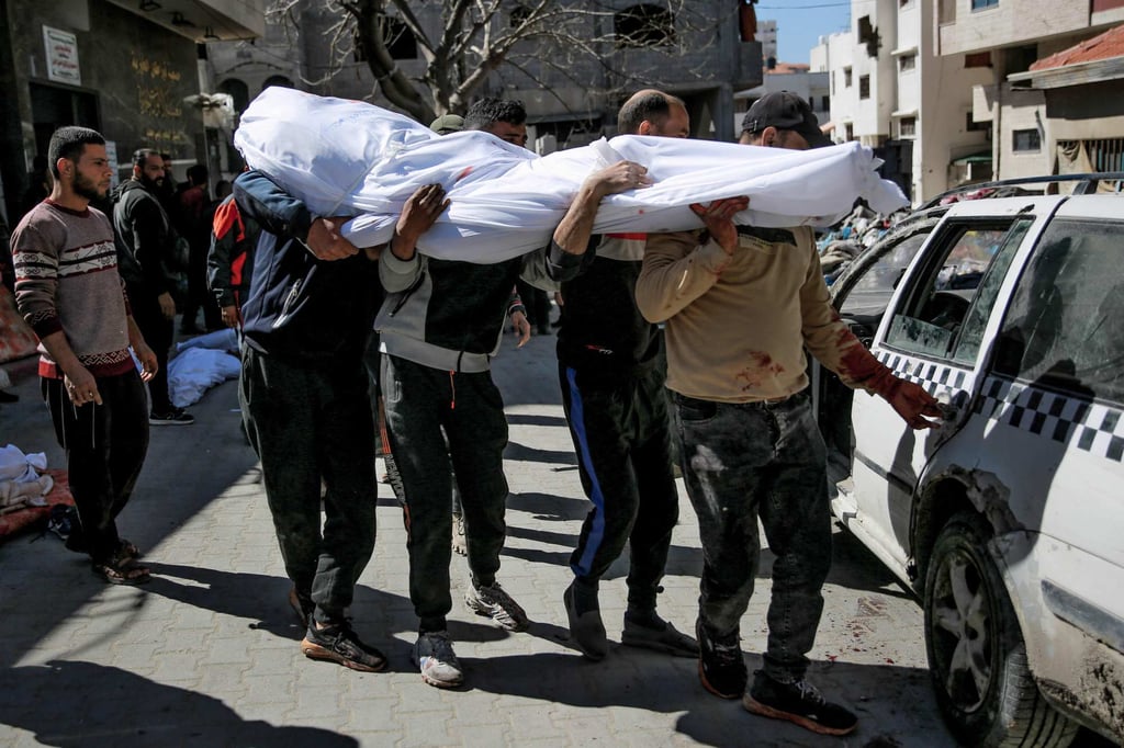 Men carry the body of a Palestinian killed in Thursday’s violence. Photo: AFP