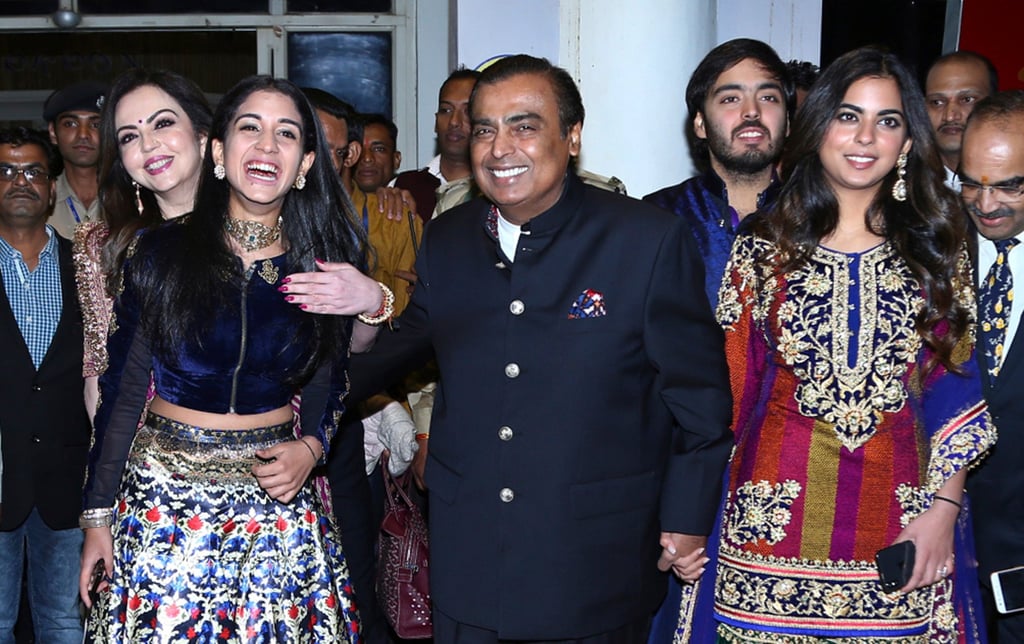 Mukesh Ambani, (centre), his wife Nita Ambani, back left, daughter Isha Ambani, right, son Anant Ambani and Radhika Merchant, front left. Photo: AP Mukesh Ambani, (centre), his wife Nita Ambani, back left, daughter Isha Ambani, right, son Anant Ambani and Radhika Merchant, front left. Photo: AP