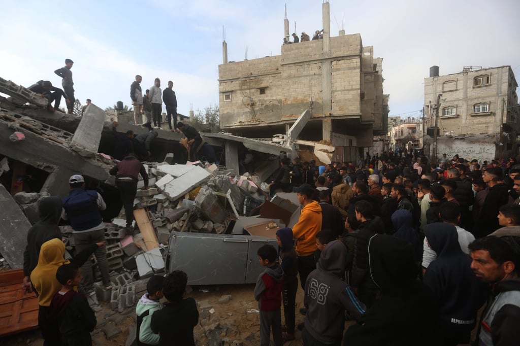 People gather around a destroyed building in Rafah on Sunday after an Israeli air strike hit the southern Gaza Strip city. Photo: Xinhua People gather around a destroyed building in Rafah on Sunday after an Israeli air strike hit the southern Gaza Strip city. Photo: Xinhua