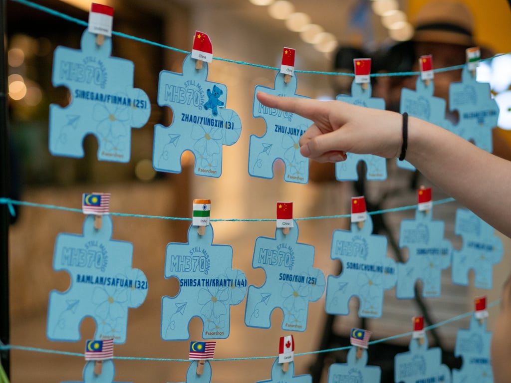 A person looks at the names of passengers and crew on doomed flight MH370, during a memorial in Malaysia on March 3. Photo: Hadi Azmi A person looks at the names of passengers and crew on doomed flight MH370, during a memorial in Malaysia on March 3. Photo: Hadi Azmi
