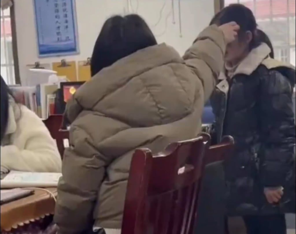 The out-of-control teacher is seen pulling the hair of one of her female pupils as the child stands silently. Photo: Baidu The out-of-control teacher is seen pulling the hair of one of her female pupils as the child stands silently. Photo: Baidu