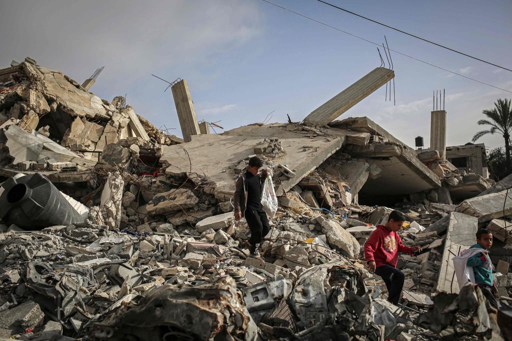 Palestinian boys make their way through the rubble of houses destroyed by Israeli bombardment in Rafah in the southern Gaza Strip on Sunday. Photo: AFP