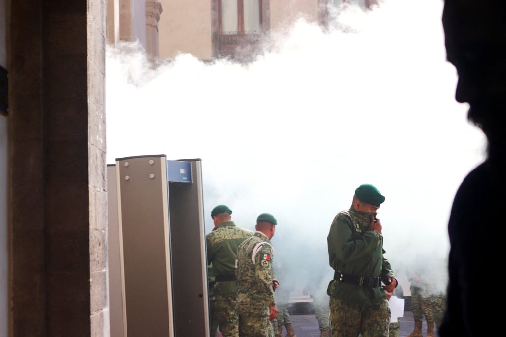 Members of the Mexican army react try to block protesters from forcing their way into the National Palace in Mexico City on Wednesday. Photo: Reuters