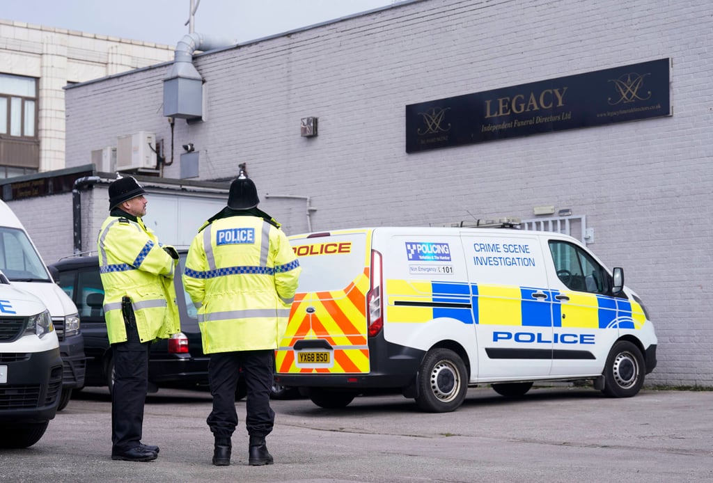 Police stand outside the Hessle Road branch of Legacy Independent Funeral Directors in Hull, England, UK on Saturday. Photo: PA via AP
