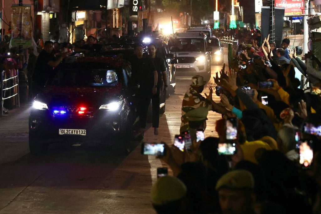 India’s Prime Minister Narendra Modi waves to supporters from a car on his way to offer prayers at the Kashi Vishwanath Hindu temple in Varanasi. Photo: AFP
