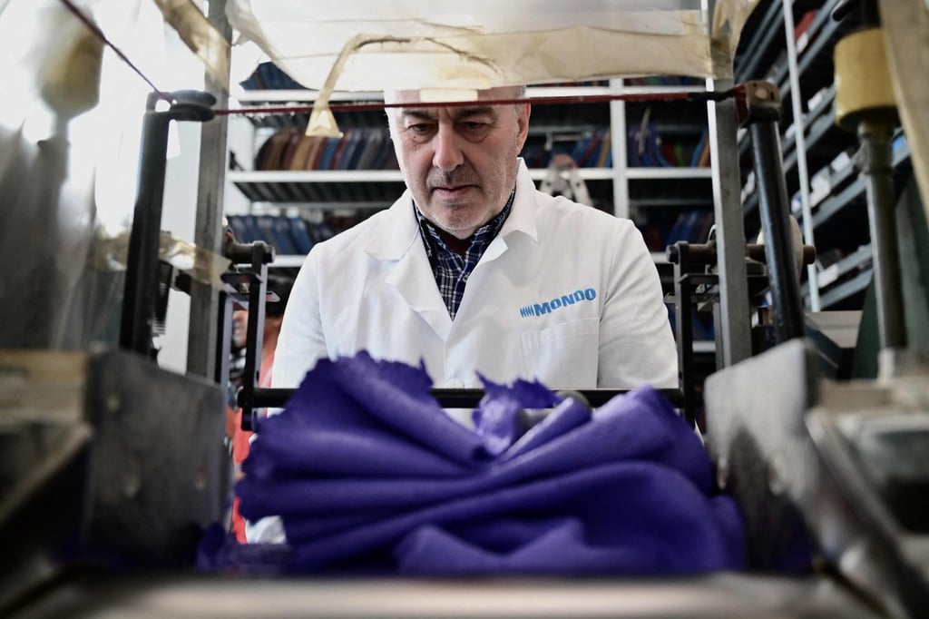 A Mondo employee works on the production of the Paris 2024 Olympics and Paralympic Games’ athletics track. Photo: AFP