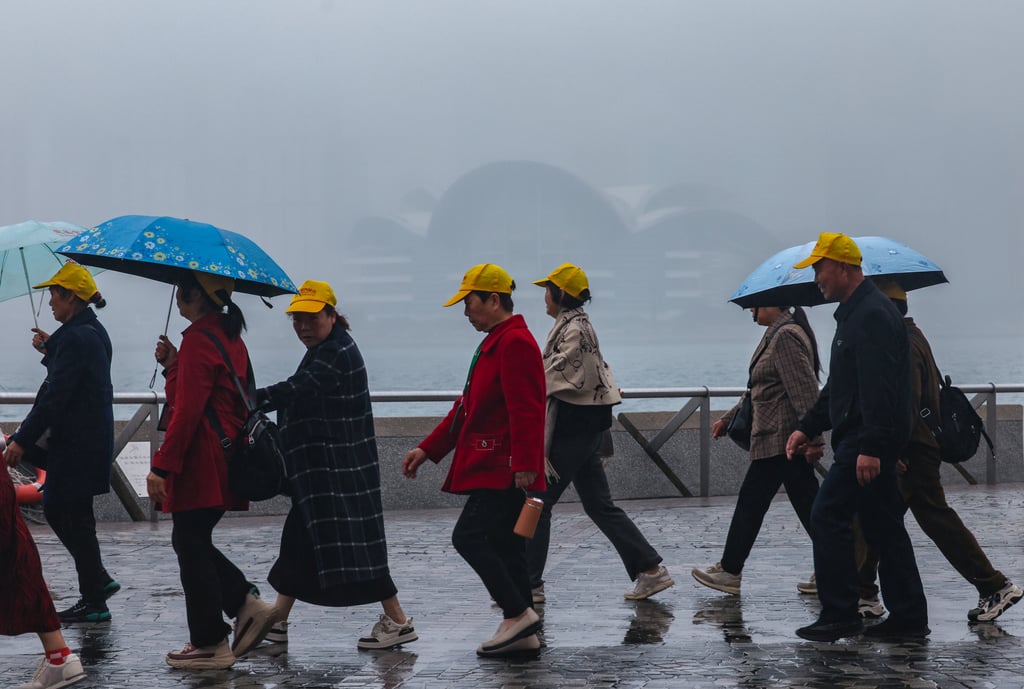 Tourists walk along Victoria Harbour in Tsim Sha Tsui. A cold front is expected to hit Hong Kong on Tuesday. Photo: Jelly Tse Tourists walk along Victoria Harbour in Tsim Sha Tsui. A cold front is expected to hit Hong Kong on Tuesday. Photo: Jelly Tse