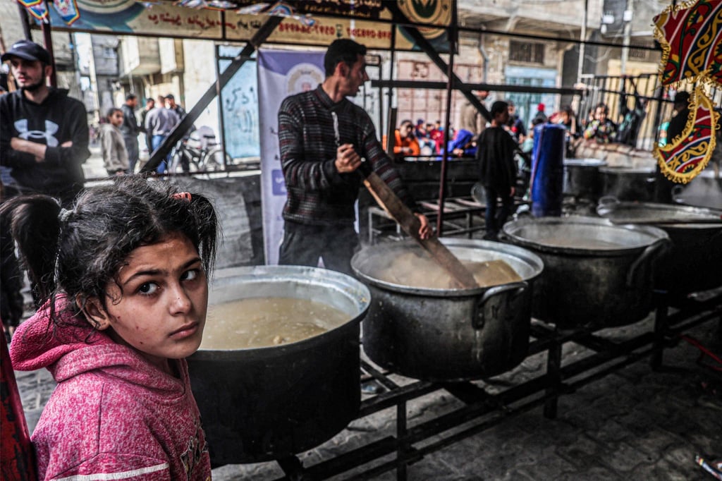 A man stirs a giant pot as displaced Palestinians queue to receive food donated by a charity organisation ahead of the fast-breaking “iftar” meal during Ramadan, in Rafah in the southern Gaza Strip on March 16, 2024. Photo: AFP A man stirs a giant pot as displaced Palestinians queue to receive food donated by a charity organisation ahead of the fast-breaking “iftar” meal during Ramadan, in Rafah in the southern Gaza Strip on March 16, 2024. Photo: AFP