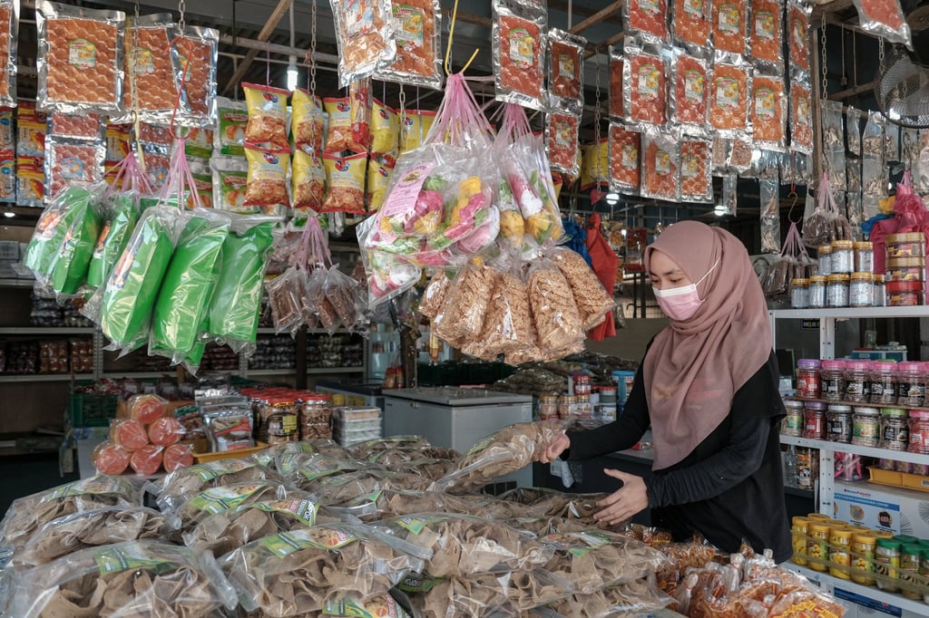 A worker arranges packaged fish crackers at a store in Terengganu. Ordinary Malaysians have been hit by the ringgit’s drop in value, as the cost of shopping surges with each depreciation. Photo: Bloomberg A worker arranges packaged fish crackers at a store in Terengganu. Ordinary Malaysians have been hit by the ringgit’s drop in value, as the cost of shopping surges with each depreciation. Photo: Bloomberg