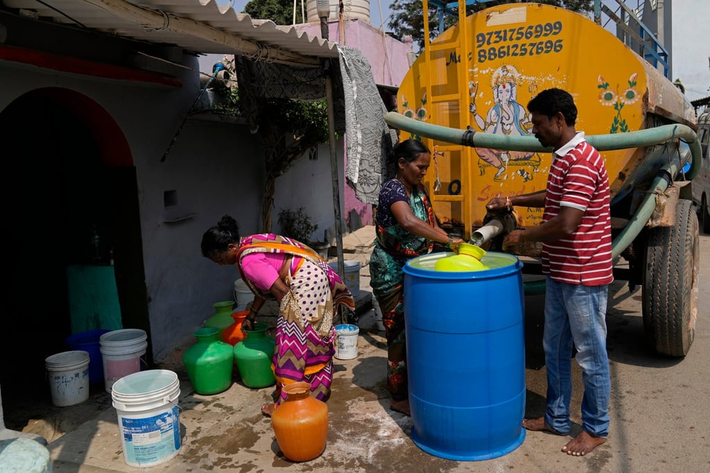 Residents of Ambedkar Nagar in Bengaluru collect drinking water from a tanker last week. Photo: AP