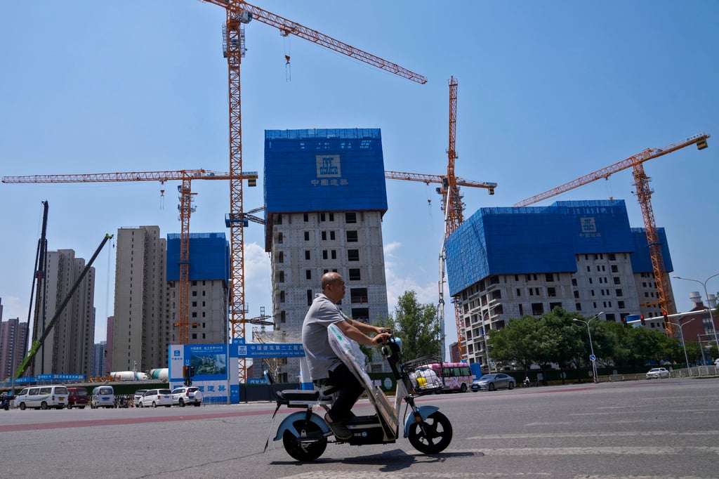 A man rides an electric bike past a residential project in Beijing in June 2023. AP Photo A man rides an electric bike past a residential project in Beijing in June 2023. AP Photo
