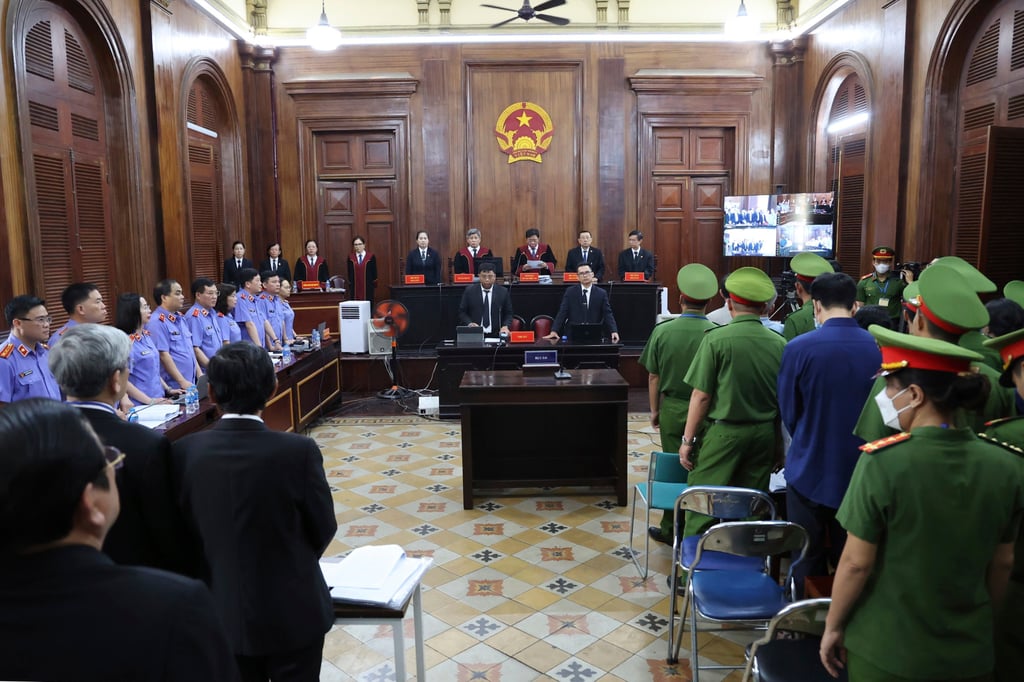People stand before Vietnamese real estate tycoon Truong My Lan enters a courtroom in Ho Chi Minh City on March 5. Photo: AP
