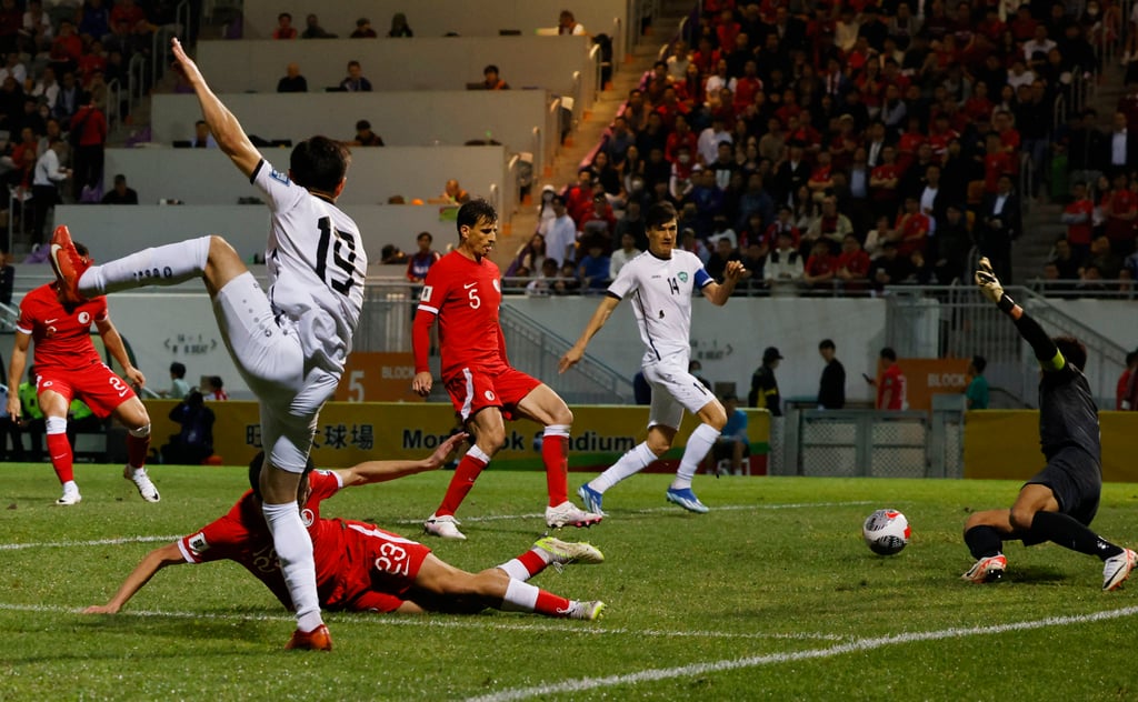 Uzbekistan’s Azizbek Turgunboev (left) knocks the ball across the face of the Hong Kong goal into the path of Eldor Shomurodov to open the scoring. Photo: Reuters