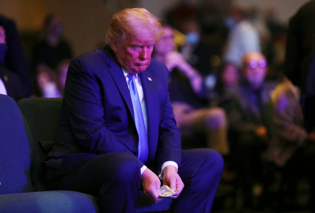 Trump counts money before donating to a church service in Las Vegas in 2020. He claims to have “almost” US$500 million in cash. Photo: Reuters Trump counts money before donating to a church service in Las Vegas in 2020. He claims to have “almost” US$500 million in cash. Photo: Reuters