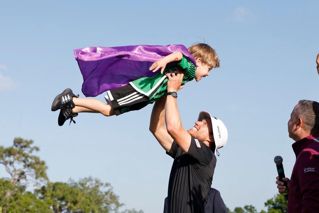 Peter Malnati tosses son Hatcher into the air after ending his eight-year winless run. Photo: USA TODAY