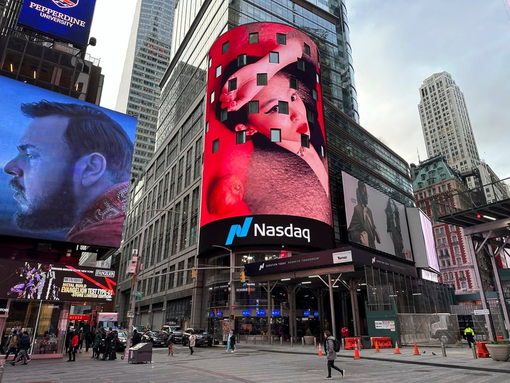 Pedestrians walk past the Nasdaq building in New York. Donald Trump’s social media company begins trading publicly on Tuesday. Photo: AP Pedestrians walk past the Nasdaq building in New York. Donald Trump’s social media company begins trading publicly on Tuesday. Photo: AP