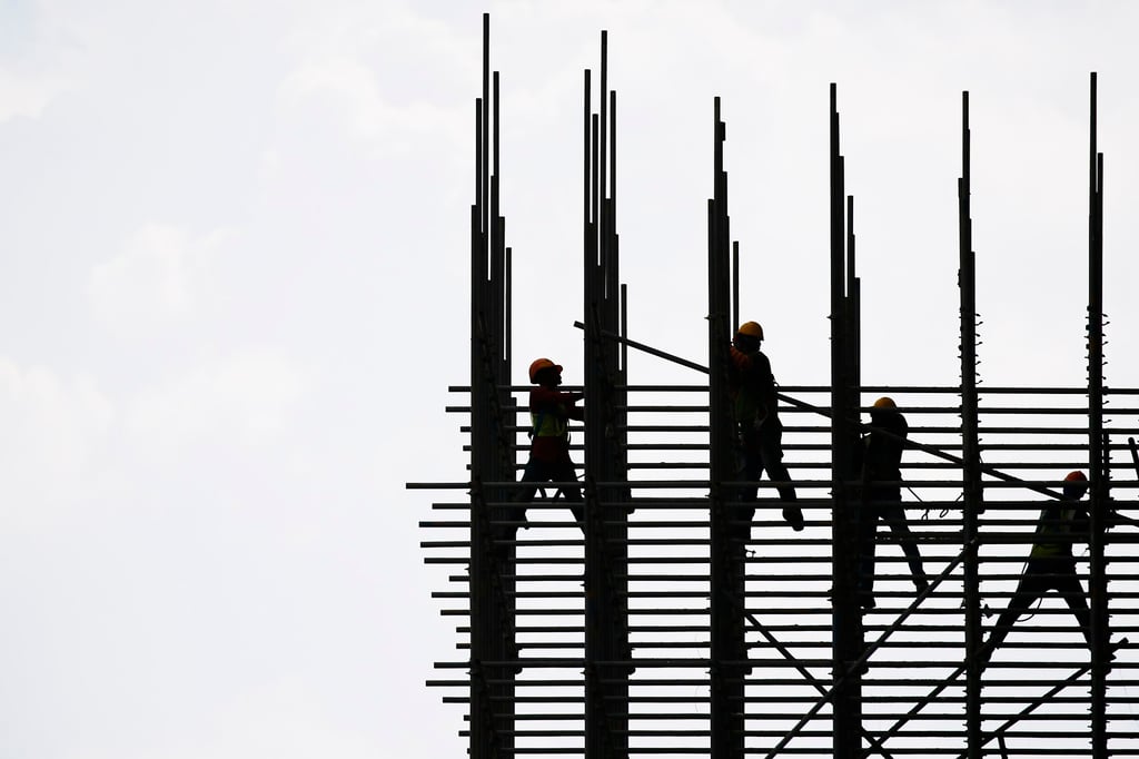 Construction workers erect scaffolding in Kuala Lumpur. Malaysia’s government is looking into ways to protect construction workers who toil for hours under the hot sun. Photo: EPA-EFE