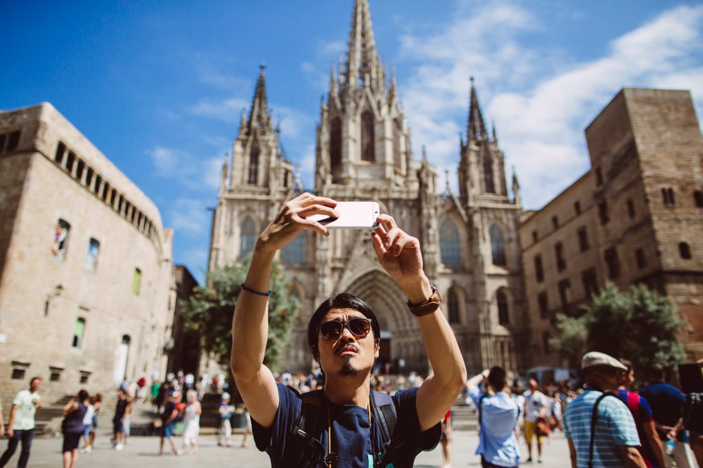 A tourist takes a selfie in front of the Barcelona Cathedral. Photo: Getty Images A tourist takes a selfie in front of the Barcelona Cathedral. Photo: Getty Images