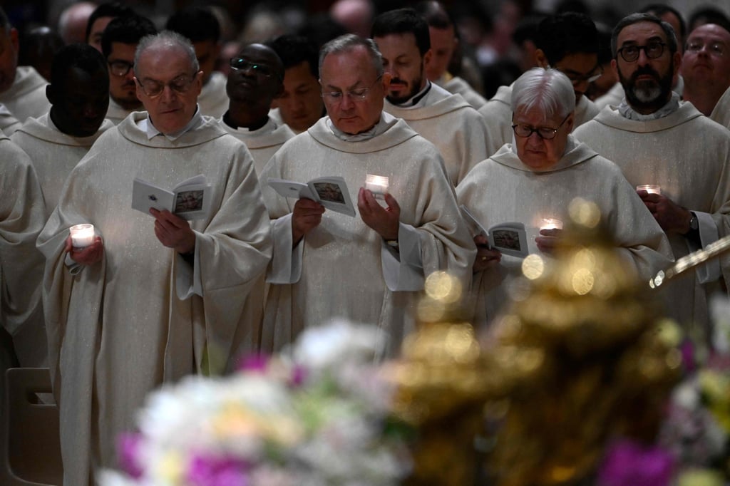 Priests hold candles during the Easter vigil as part of the Holy Week celebrations at St Peter’s Basilica in the Vatican. Photo: AFP