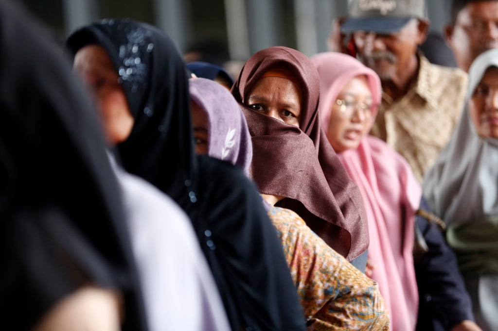 Residents queue to register their name to receive food aid in Banda Aceh on March 6. Photo: EPA-EFE