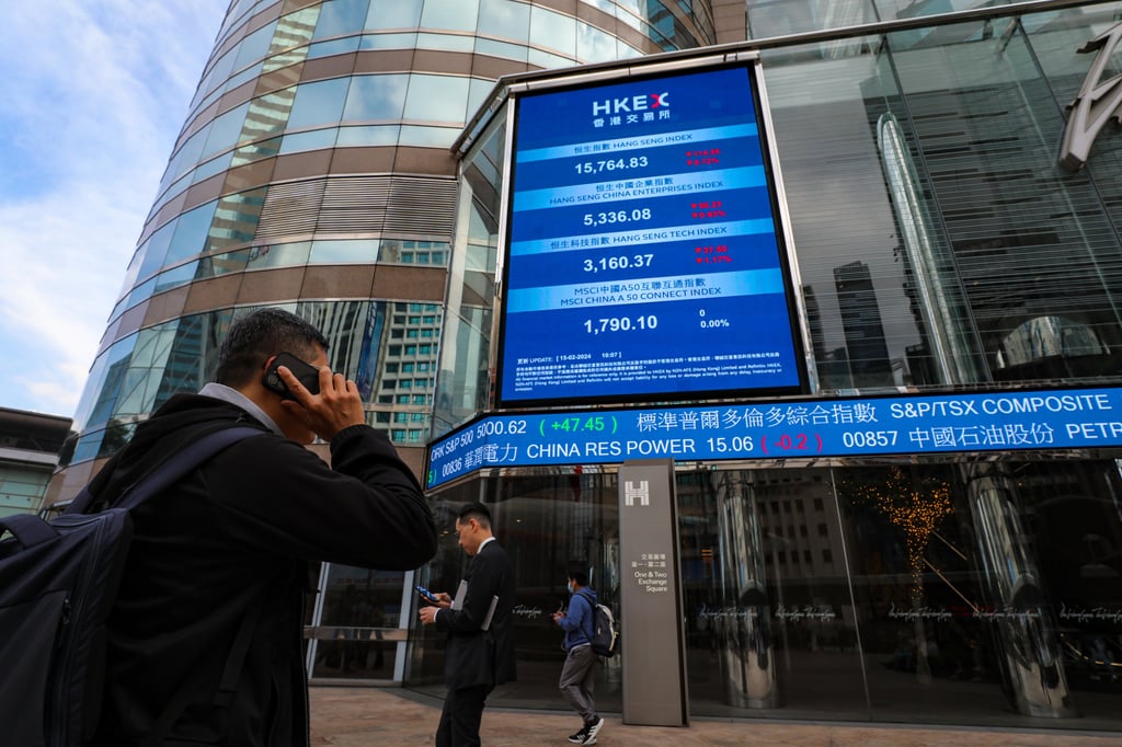People pass under screens showing index and stock prices outside Exchange Square in Central, home of the city’s bourse operator Hong Kong Exchanges and Clearing, on February 15, 2024. Photo: Sun Yeung People pass under screens showing index and stock prices outside Exchange Square in Central, home of the city’s bourse operator Hong Kong Exchanges and Clearing, on February 15, 2024. Photo: Sun Yeung