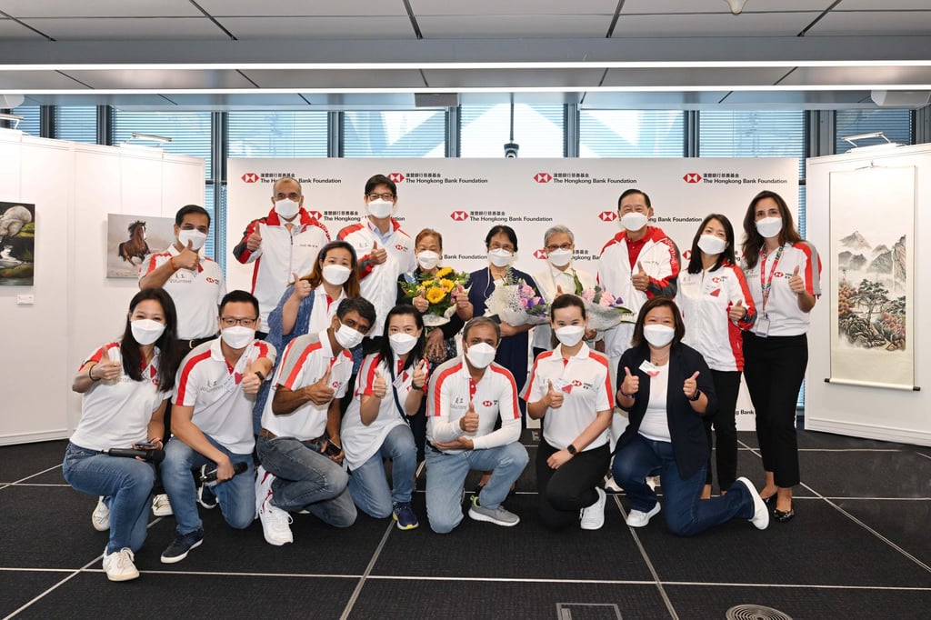 HSBC volunteers and beneficiaries, including widow Ivy To (back row, fourth left) and Winky Kwok (front row, fourth left) digital manager at HSBC, join Peter Wong (back row, third right), chairman of HSBC Asia-Pacific, and David Liao (back row, third left), co-chief executive of HSBC Asia-Pacific, at the ‘Share Your Dreams’ Exhibition in 2022.