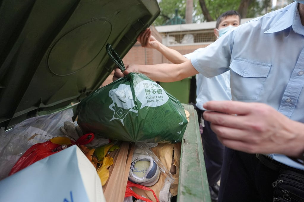 A resident throws a bag of garbage at a refuse collection point outside On Ning Lau, Moon Lok Dai Ha, in Tseun Wan. Photo: Eugene Lee A resident throws a bag of garbage at a refuse collection point outside On Ning Lau, Moon Lok Dai Ha, in Tseun Wan. Photo: Eugene Lee