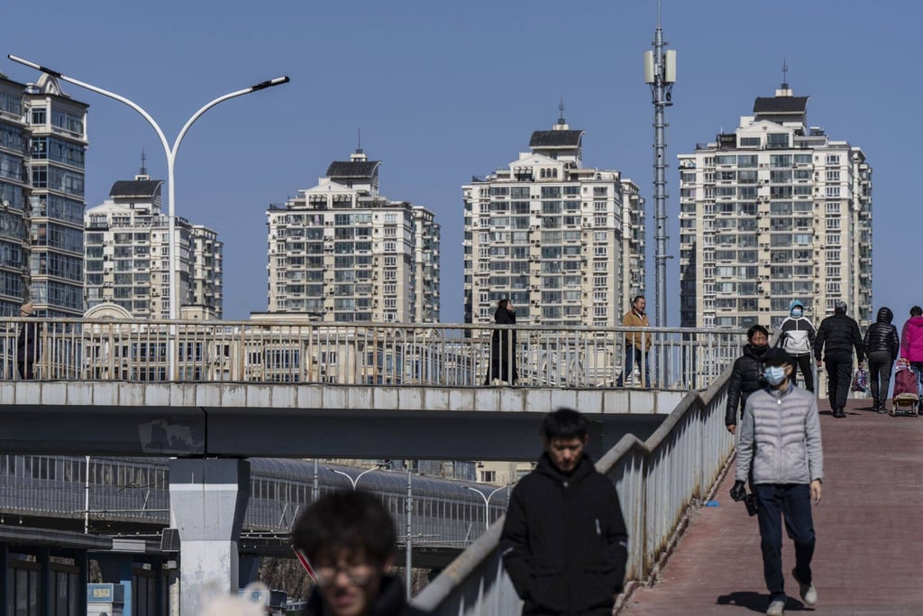 Pedestrians cross a footbridge near residential buildings in Beijing on March 3, 2024. Photo: Bloomberg Pedestrians cross a footbridge near residential buildings in Beijing on March 3, 2024. Photo: Bloomberg
