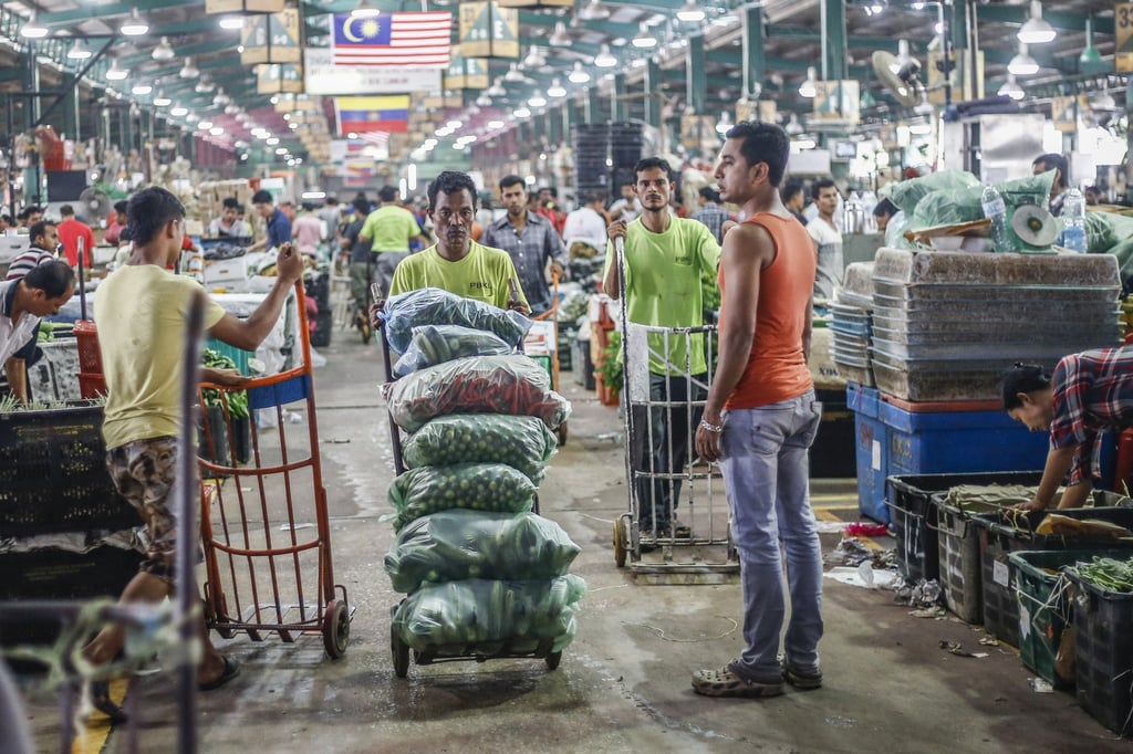 Migrant workers from Bangladesh and Myanmar work as general labourers at a wholesale market in Kuala Lumpur. Photo: Shutterstock