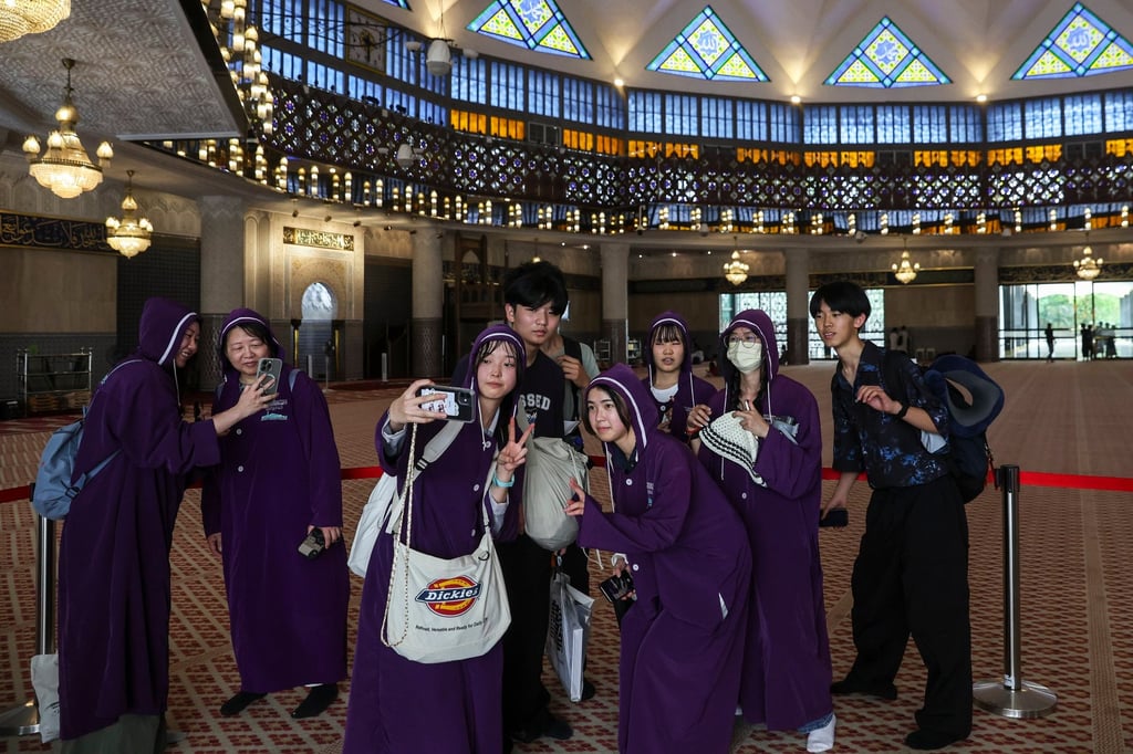 Tourists take pictures at a mosque Kuala Lumpur during the International Day to Combat Islamophobia last month. Malaysia and Thailand together generated about US$48 billion in tourism revenue last year. Photo: EPA-EFE