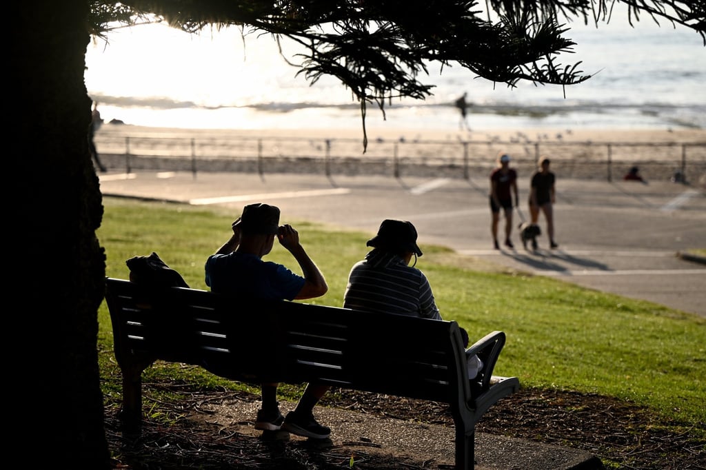 People sit on a bench at in Sydney. New Zealand’s neighbour Australia has said it would halve its migrant intake over the next two years. Photo: EPA-EFE