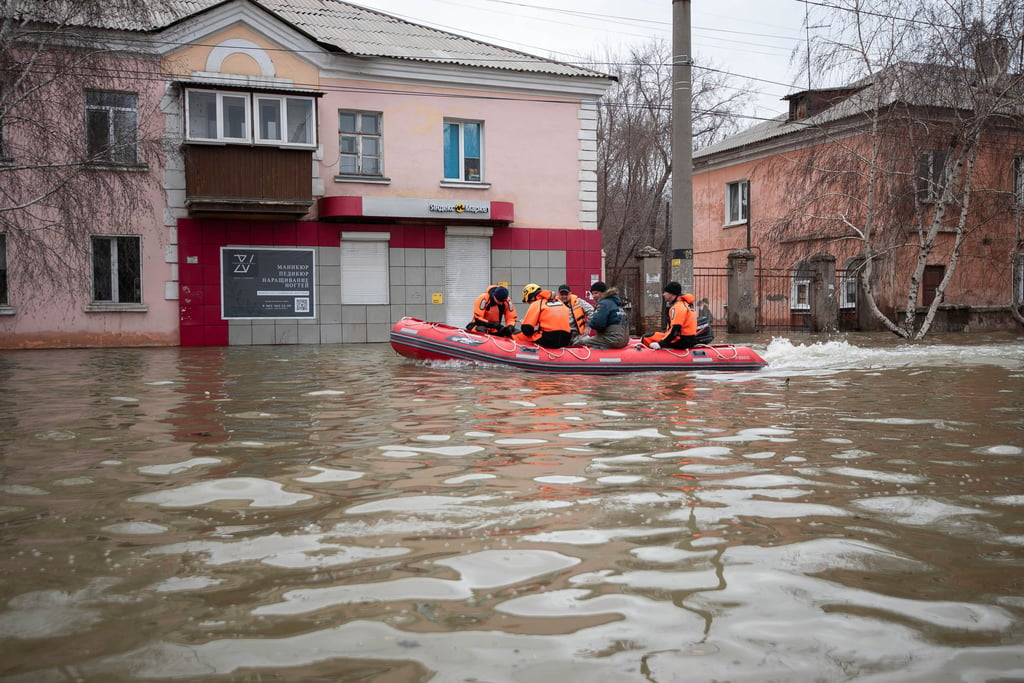 Emergency workers and police ride a boat in Orsk. Photo: AP