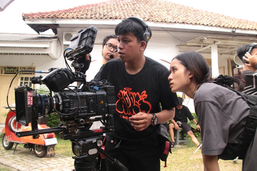 A director of photography and his assistant check the framing of a shot during a film shoot in Jakarta. Photo: Shutterstock