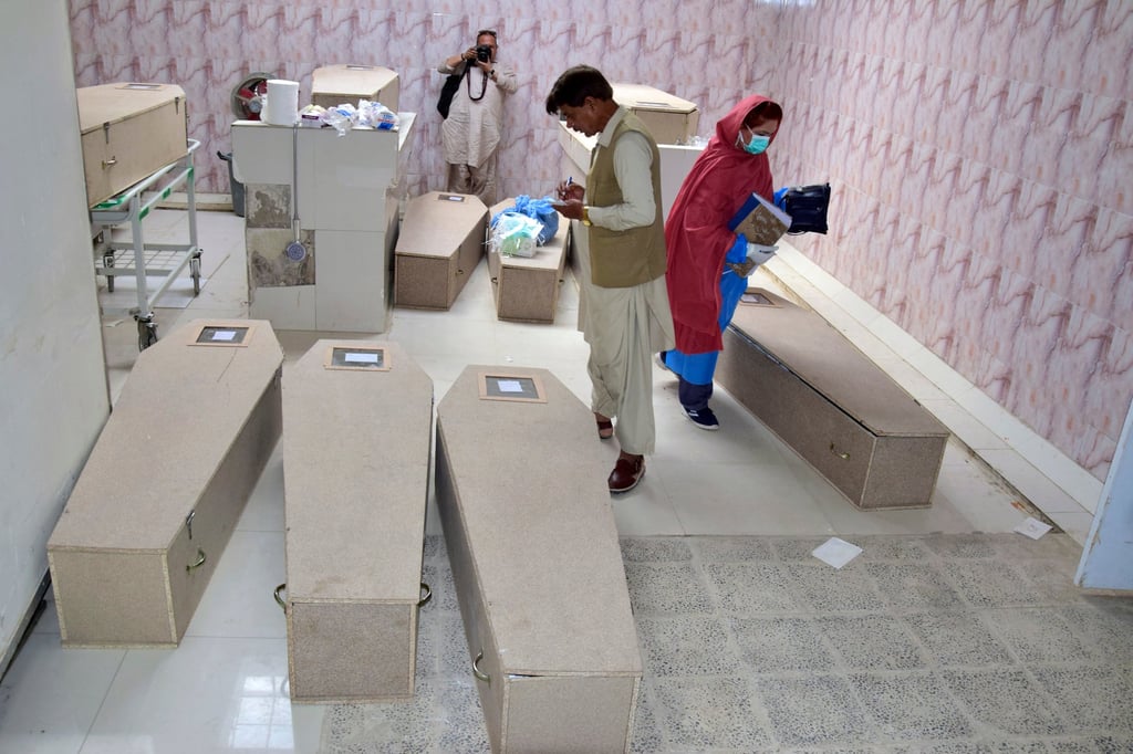 A hospital morgue worker in Pakistan makes notes related to those killed on Friday by gunmen. Photo: AP