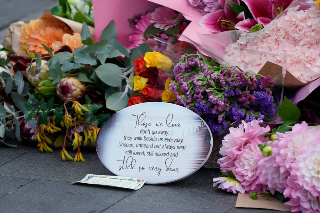 A note is left with flower tributes near a crime scene at Bondi Junction in Sydney on Sunday. Photo: AP