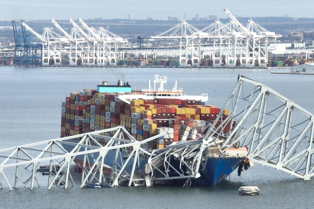 The steel frame of the Francis Scott Key Bridge sits on top of a container ship after the bridge collapsed. Photo: AFP