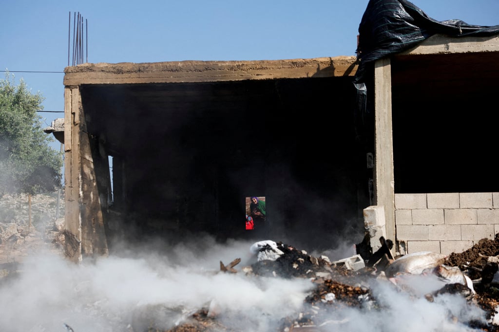 A Palestinian woman inspects the damage to her house after Israeli settlers attacked the village of al-Mughayyer, in the Israeli-occupied West Bank, on Saturday. Photo: Reuters