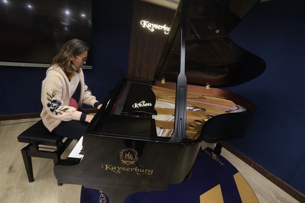 A visitor to the Hong Kong recital hall and showroom of Pear River’s Kayserburg brand plays a grand piano. Photo: Jonathan Wong