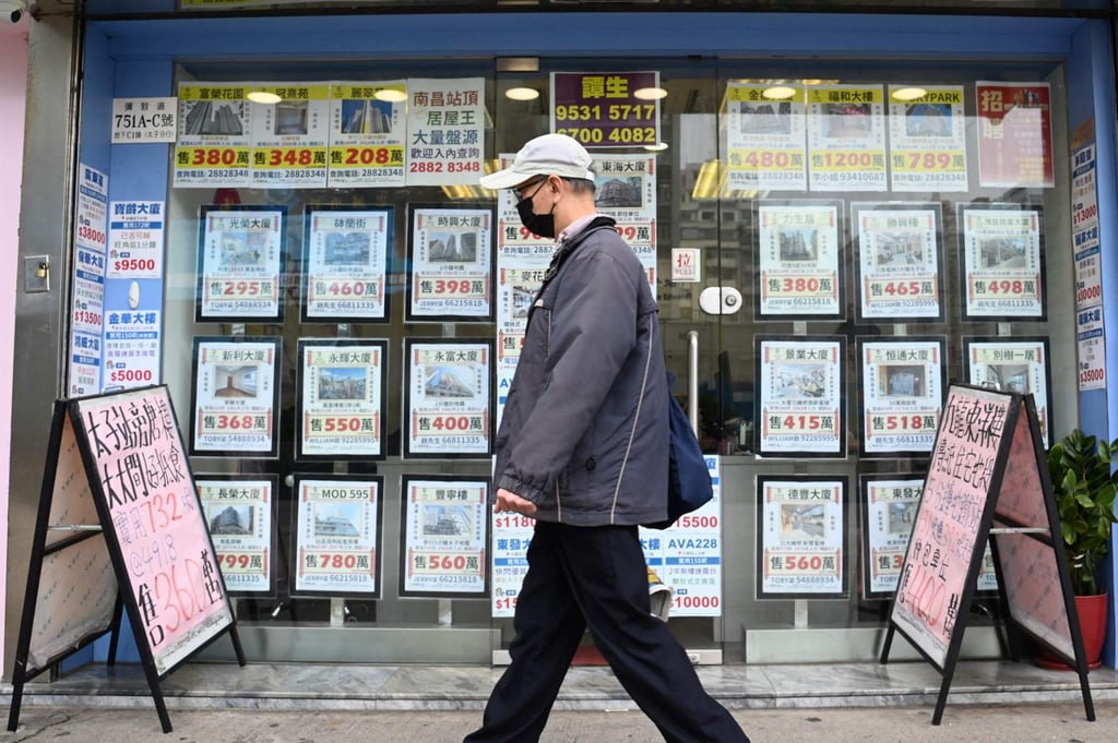A pedestrian walks past a property agent in Hong Kong on February 28, 2024. Photo: AFP A pedestrian walks past a property agent in Hong Kong on February 28, 2024. Photo: AFP