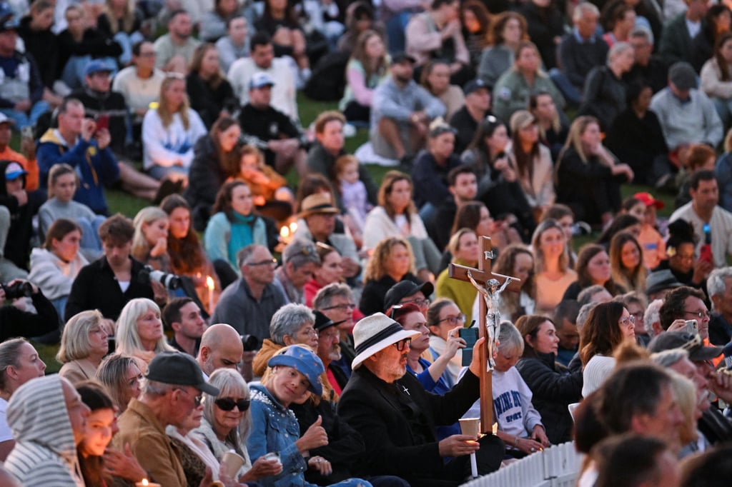 A man holds a cross during a candlelight memorial, recognising the victims of a fatal stabbing attack at Bondi Junction Westfield shopping centre, in Sydney, Australia, on Sunday. Photo: Reuters A man holds a cross during a candlelight memorial, recognising the victims of a fatal stabbing attack at Bondi Junction Westfield shopping centre, in Sydney, Australia, on Sunday. Photo: Reuters