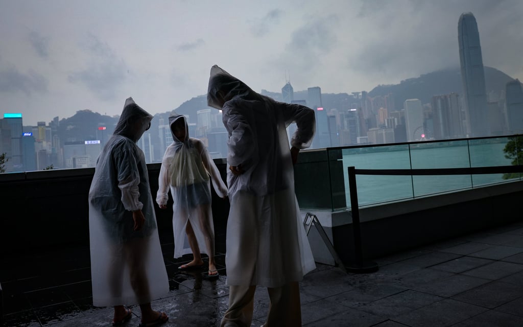 Threatening skies over Tsim Sha Tsui as people don wet weather gear. Photo: Jelly Tse Threatening skies over Tsim Sha Tsui as people don wet weather gear. Photo: Jelly Tse