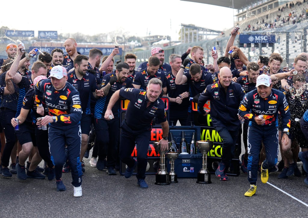 Red Bull’s Max Verstappen (left), team principal Christian Horner, chief technical officer Adrian Newey and driver Sergio Perez run as team members spray Reb Bull after the Japanese Grand Prix. Photo: EPA-EFE