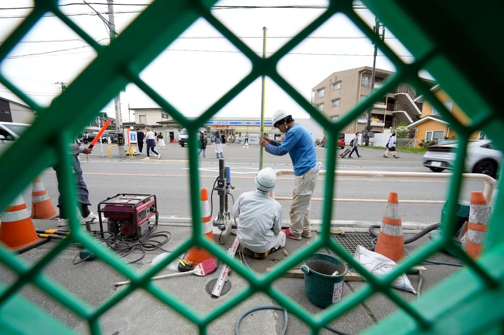 Workers set up a barrier near the Lawson convenience store in Fujikawaguchiko town on Tuesday. Photo: AP