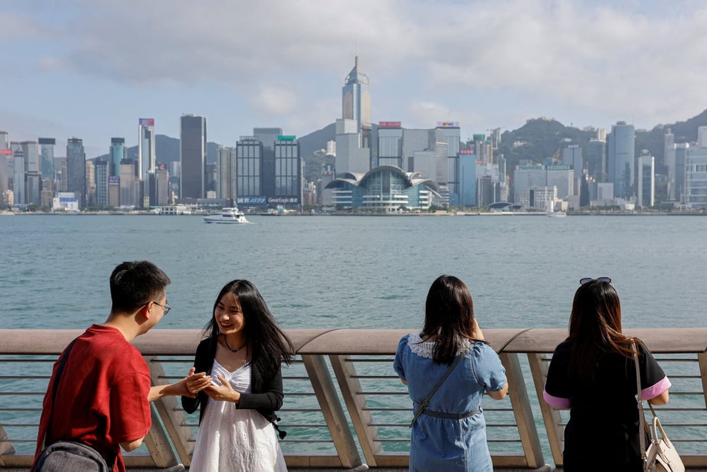 Mainland Chinese tourists take photo of the skyline of buildings at Tsim Sha Tsui, in Hong Kong, China. Photo: Reuters