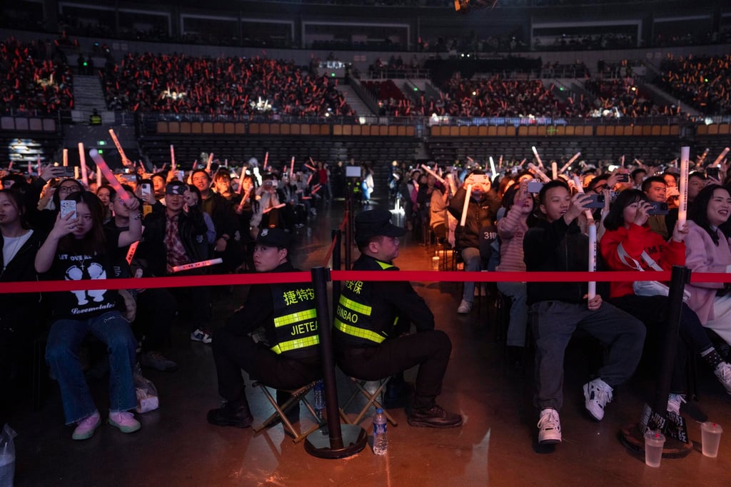 Security guards watch over fans of Chinese rappers during a performance in Chengdu, China. Photo: AP Security guards watch over fans of Chinese rappers during a performance in Chengdu, China. Photo: AP