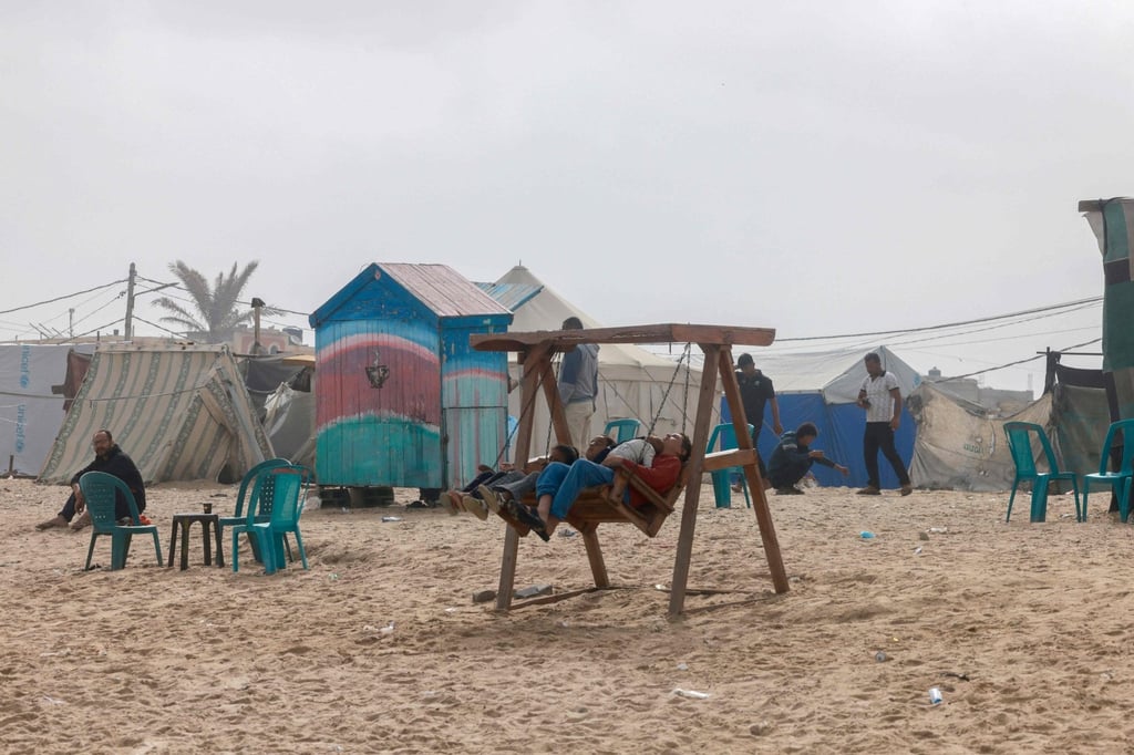 Displaced Palestinians cool down at the beach to escape the searing heat in their camp tents in Rafah. Photo: AFP Displaced Palestinians cool down at the beach to escape the searing heat in their camp tents in Rafah. Photo: AFP