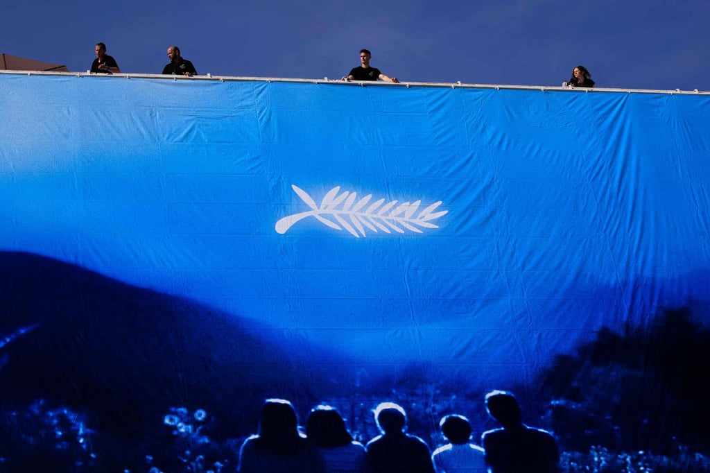 Workers hang the official poster of the 77th Cannes Film Festival in Cannes, France. Photo: AFP